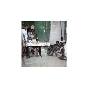 Nikolay Drachinsky. Newcomer Tailor Nuer Boy Ahut at the Sewing Machine and Young Tailor Lual, From Shilluk Tribe, in the Gate of Omar Obasher’s Store at the Market. City Al Manaqil, Upper Nile Province. Sudan, 1957. © Nikolay Drachinsky archive, courtesy of Alla Vakhromeeva, Archive Paper 8"x8", $400